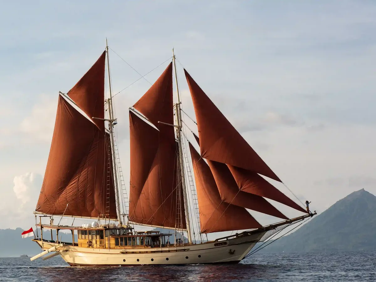 A phinisi sailing under red sails