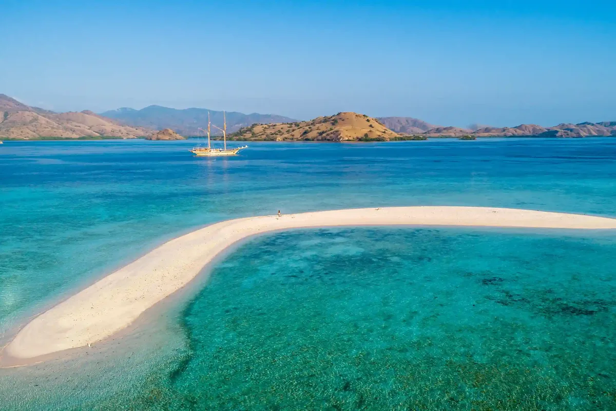A phinisi anchored off the Taka Makassar sandbar in Komodo National Park